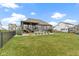 Large, green back yard with an outdoor kitchen, patio area, and a covered deck at 18271 Lake Winds Dr, Westfield, IN 46074
