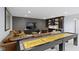 A stylish finished basement with a shuffleboard table, a bar, and a plush leather sofa is ideal for entertaining at 18271 Lake Winds Dr, Westfield, IN 46074