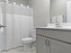 Bathroom showcasing a shower with a white curtain, gray cabinets, and a modern sink at 18271 Lake Winds Dr, Westfield, IN 46074