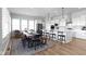 Bright dining area with large windows, modern table and chairs, and an open kitchen concept at 18271 Lake Winds Dr, Westfield, IN 46074