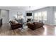 Spacious living room boasts wood floors, plush leather sofas, and a cozy fireplace at 18271 Lake Winds Dr, Westfield, IN 46074