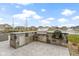Backyard outdoor kitchen featuring a stainless steel grill, an Egg style grill, and a view of the lake at 18271 Lake Winds Dr, Westfield, IN 46074