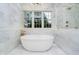 Spa-like bathroom featuring a soaking tub, marble accents, and natural light at 1997 Finchley Rd, Carmel, IN 46032