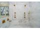 Luxurious bathroom featuring marble walls, rain shower, and gold fixtures at 1997 Finchley Rd, Carmel, IN 46032