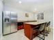Basement kitchenette with stainless steel fridge, granite counters, and seating for four at 1997 Finchley Rd, Carmel, IN 46032