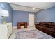 Comfortable living room with blue walls, a brown sofa, wooden desk, and decorative cabinet at 1997 Finchley Rd, Carmel, IN 46032