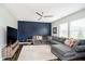 Cozy living room featuring an accent wall, plush sectional, and hardwood floors, perfect for relaxation at 19992 Fenside Xing, Westfield, IN 46074