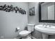 Half bathroom includes a modern sink with pedestal and a decorative mirror and wall art at 2067 Rhettsbury St, Carmel, IN 46032