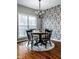 Charming dining room features a round wooden table, black chairs, decorative wallpaper, and a large window at 2067 Rhettsbury St, Carmel, IN 46032