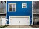 Bright blue house featuring a white garage door and well-maintained exterior at 2067 Rhettsbury St, Carmel, IN 46032