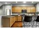 Spacious kitchen boasts granite countertops, wooden cabinetry, stainless steel appliances, and a modern island at 2067 Rhettsbury St, Carmel, IN 46032