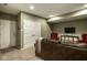 Finished basement living room with brown leather furniture, tv and a closet at 2067 Rhettsbury St, Carmel, IN 46032