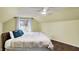 A bedroom with a sloped ceiling features a large bed, ceiling fan, and a window at 214 W Elbert St, Indianapolis, IN 46217