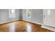 Neutral bedroom featuring hardwood floors, two large windows, a white front door, and white trim at 214 W Elbert St, Indianapolis, IN 46217