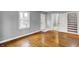 Bright room featuring hardwood floors, natural light, white trim, and access to an additional room at 214 W Elbert St, Indianapolis, IN 46217