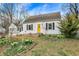 Charming home featuring white siding, a bright yellow front door, and fresh landscaping in the front yard at 214 W Elbert St, Indianapolis, IN 46217