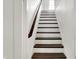 A staircase with white steps and a dark-stained wooden railing, leading to the upper floor at 214 W Elbert St, Indianapolis, IN 46217