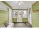 Enclosed sunroom featuring olive green walls, beadboard ceiling and ample windows at 214 W Elbert St, Indianapolis, IN 46217
