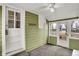 Enclosed sunroom with olive green walls, beadboard ceiling and multiple windows at 214 W Elbert St, Indianapolis, IN 46217