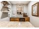 Stylish bar area with granite countertop, wine fridge, shelving, and decorative mirror at 224 Brierley Way, Carmel, IN 46032