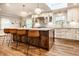 The kitchen boasts an island with seating, pendant lights, and white cabinets, blending style and functionality at 224 Brierley Way, Carmel, IN 46032