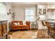 Cozy living area featuring an orange couch and view into a modern kitchen, offering a blend of comfort and convenience at 224 Brierley Way, Carmel, IN 46032