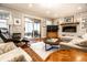Cozy living room with brick fireplace, wood floors, and access to a screened-in porch at 224 Brierley Way, Carmel, IN 46032