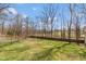 Spacious backyard with an ample grassy area, partially enclosed by a wooden fence and mature trees at 251 Howard Rd, Greenwood, IN 46142