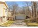 A charming detached garage with white door sits on a sunny lot with convenient driveway access at 251 Howard Rd, Greenwood, IN 46142