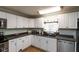 Bright kitchen with white cabinets, stainless steel appliances, a double sink and wood floors at 251 Howard Rd, Greenwood, IN 46142