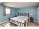 Well-lit main bedroom with soft blue walls, comfy carpet, and a large bed with an iron frame at 251 Howard Rd, Greenwood, IN 46142