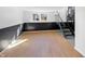 Finished basement features wood-look floors, black paneling and staircase at 2928 Sheffield Dr, Indianapolis, IN 46229