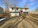Split-level home featuring a red front door, two-car garage, and well-maintained landscaping at 2928 Sheffield Dr, Indianapolis, IN 46229