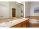 Bathroom featuring double sinks, marble countertop, and jetted tub at 355 E Ohio St # 221, Indianapolis, IN 46204