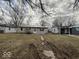 A single-story house with an expansive front yard and trees is pictured on an overcast day at 3812 S Ebright St, Muncie, IN 47302