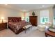 Comfortable main bedroom with bedside tables, sitting area, and natural light from two windows at 3941 Stratfield Way, Westfield, IN 46074