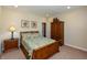 Bedroom featuring neutral walls, a bed with floral accents, a bedside table and a dark wood cabinet at 3941 Stratfield Way, Westfield, IN 46074