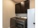 Functional laundry room showcasing modern, front-load washer and dryer with overhead cabinets for storage at 3941 Stratfield Way, Westfield, IN 46074