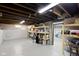 Unfinished basement space with exposed ceiling, concrete walls, and shelving along the wall at 3960 N Park Ave, Indianapolis, IN 46205