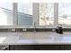 Kitchen sink with marble countertop, gray backsplash, and window view of the outdoors at 3960 N Park Ave, Indianapolis, IN 46205