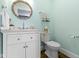 Charming powder room with a round mirror, toilet, and a white vanity at 3960 N Park Ave, Indianapolis, IN 46205