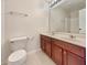 Bathroom featuring double sinks, a large mirror, wood cabinets, and tile floors, complemented by a toilet at 5099 Nicodemus Dr, Plainfield, IN 46168