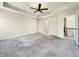 Spacious bedroom featuring tray ceilings, ceiling fan, plush gray carpeting, and an ensuite bathroom at 5099 Nicodemus Dr, Plainfield, IN 46168