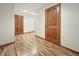 Hallway featuring wood laminate flooring, with two doors, and neutral-colored walls and baseboards at 5099 Nicodemus Dr, Plainfield, IN 46168