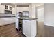 Gourmet kitchen featuring an island with a wine cooler, stainless appliances, and white cabinetry at 5099 Nicodemus Dr, Plainfield, IN 46168
