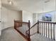 Upper landing with wood railing, plush carpeting, and a view of the outdoors through a large window at 5099 Nicodemus Dr, Plainfield, IN 46168