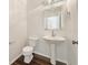 Stylish powder room with a pedestal sink, modern fixtures, and attractive flooring at 5099 Nicodemus Dr, Plainfield, IN 46168