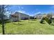 Large backyard with well-manicured lawn, young trees, and a trampoline at 5941 Bonneville Way, Indianapolis, IN 46237