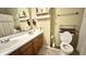 Neutral bathroom featuring a double vanity, white shelves, and a standard toilet at 5941 Bonneville Way, Indianapolis, IN 46237