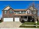 Charming two-story home with a brick and vinyl exterior, two-car garage, and manicured front lawn under a bright blue sky at 5941 Bonneville Way, Indianapolis, IN 46237